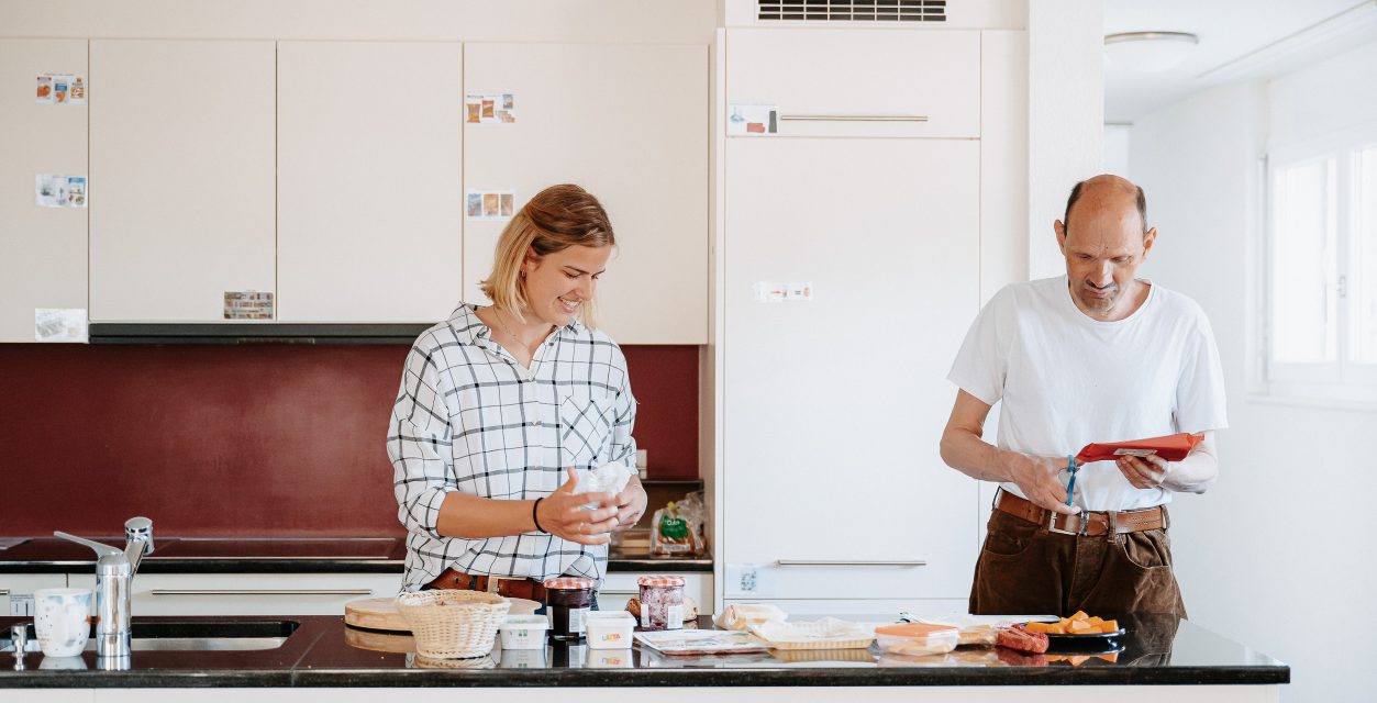 zwei Menschen stehen in der Küche und bereiten gemeinsam ein Essen vor