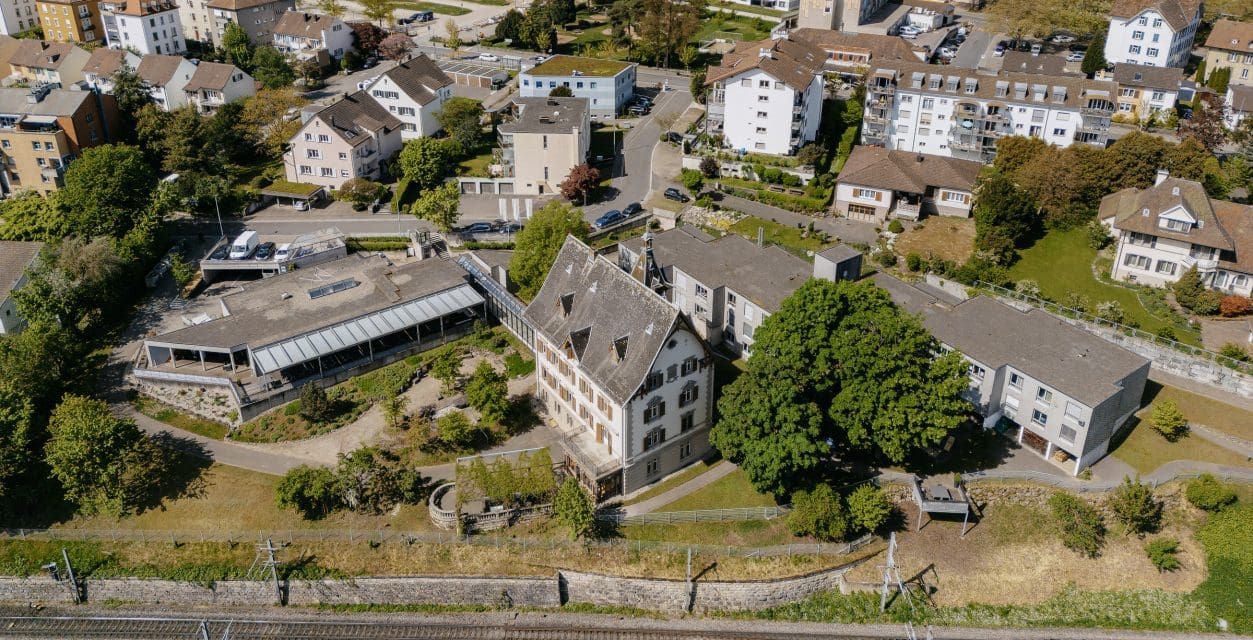 Luftaufnahme vom Gelände diheiplus und Umgebung mehrere Häuser und Wohnblöcke, Bäume und Grünflächen